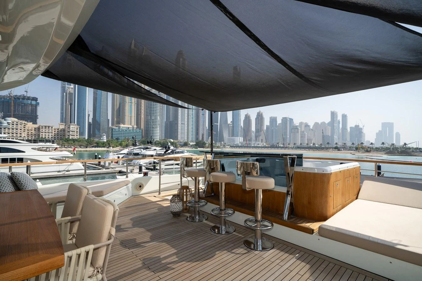 The sundeck features a shaded area with bar stools and a jacuzzi, offering a luxurious space to relax and enjoy the view. aboard M/Y MASHA Yacht for Sale