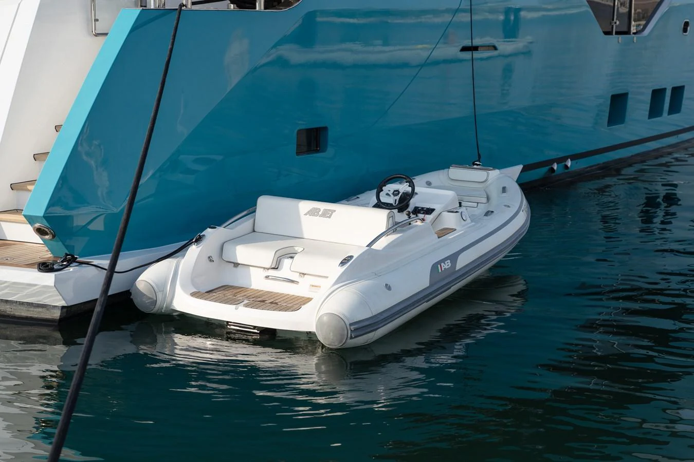 A sleek tender is docked alongside a luxurious yacht, ready for excursions. aboard M/Y MASHA Yacht for Sale