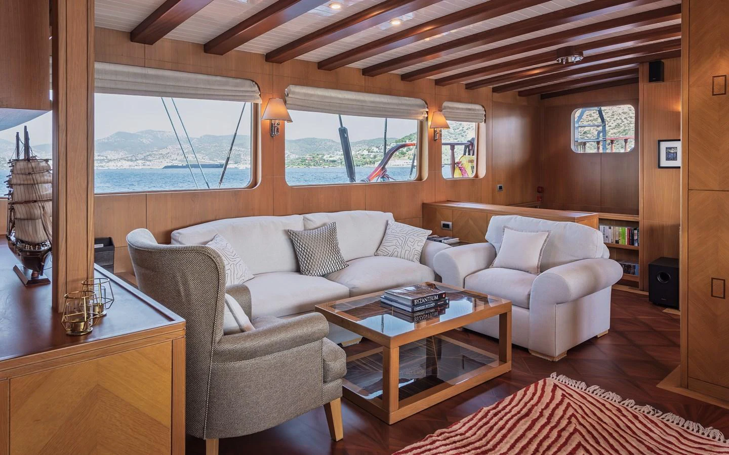 The salon offers a cozy and inviting space with plush seating and large windows providing scenic views. aboard AEGEAN Yacht for Sale