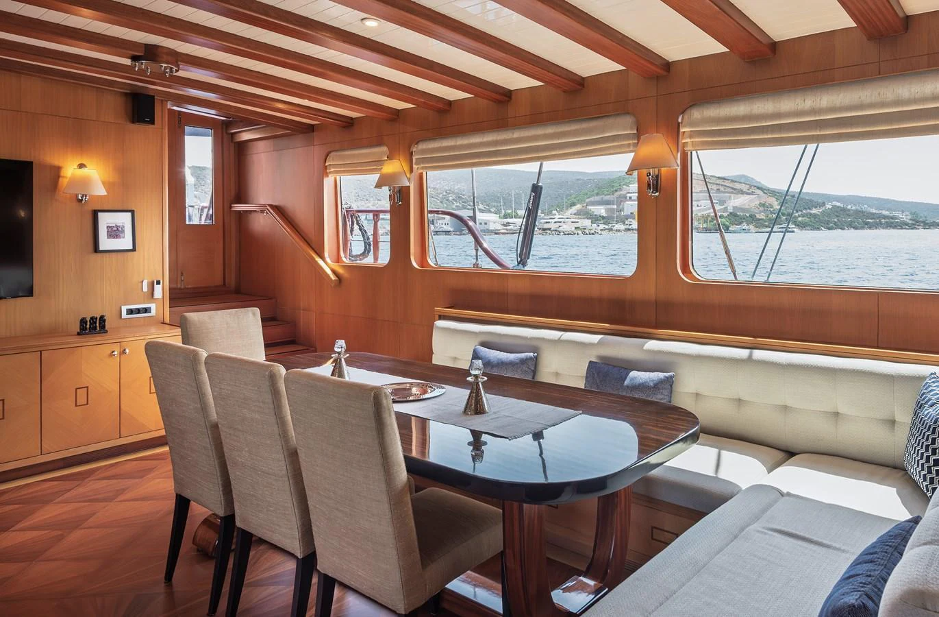 The salon features a spacious dining area with elegant wood finishes and large windows offering scenic views. aboard AEGEAN Yacht for Sale