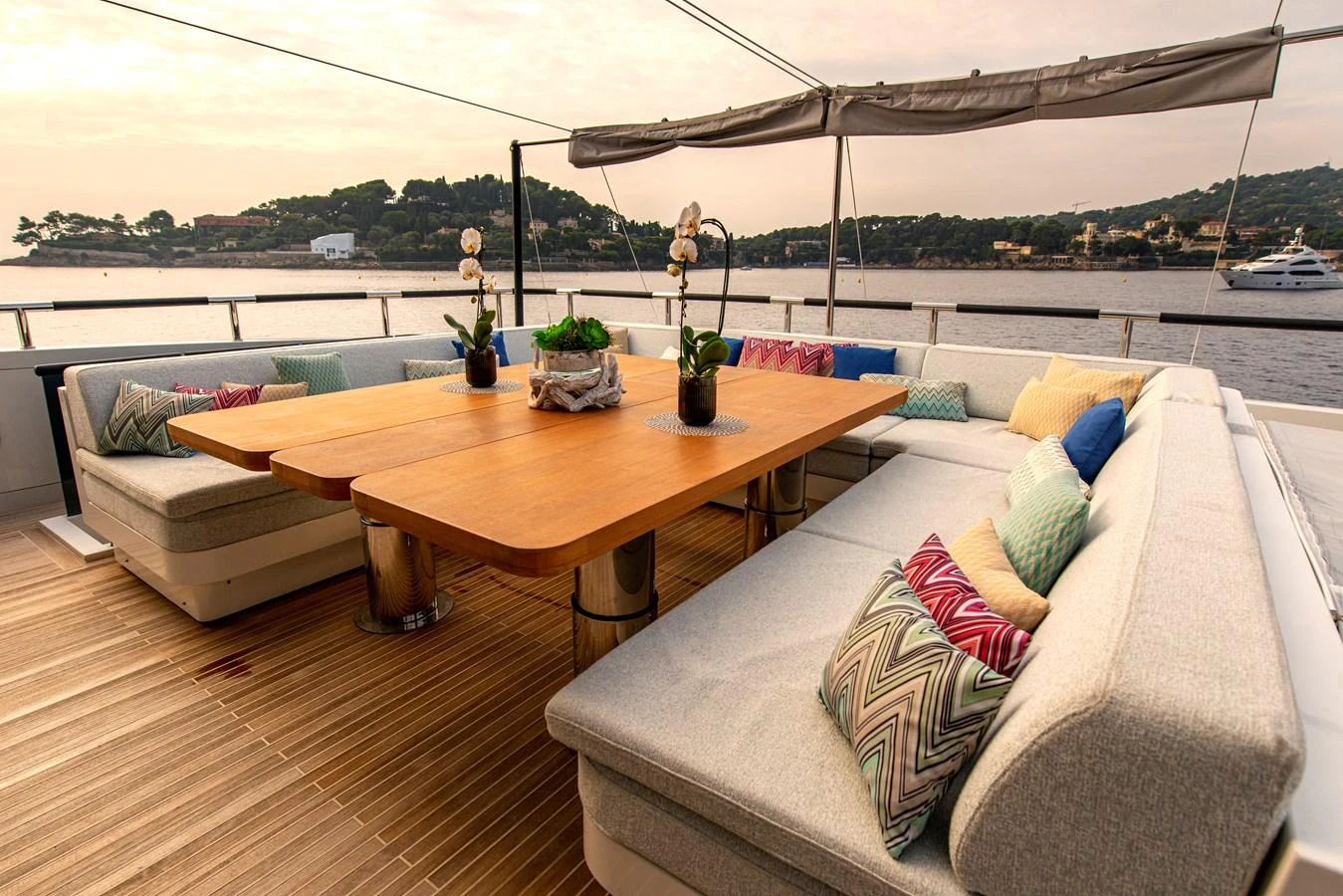 The aft deck features a spacious and inviting outdoor dining area with plush seating and a large wooden table, perfect for alfresco meals with a view. aboard GEMS II Yacht for Sale