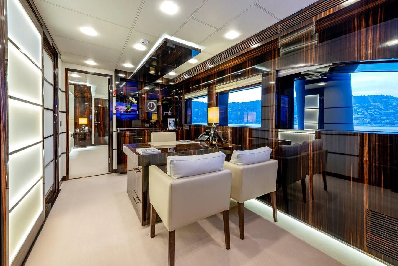 The yacht's office features luxurious wood paneling and comfortable seating. aboard GEMS II Yacht for Sale