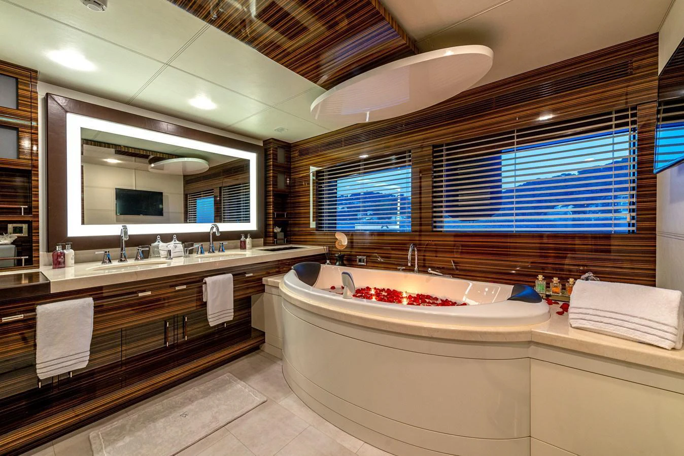 The luxurious bathroom features a spacious bathtub, elegant wood paneling, and modern fixtures. aboard GEMS II Yacht for Sale