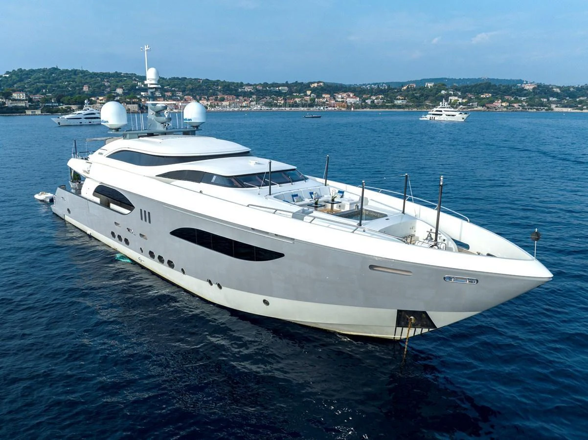 A sleek and modern yacht cruising on calm waters with a scenic coastal backdrop. aboard GEMS II Yacht for Sale