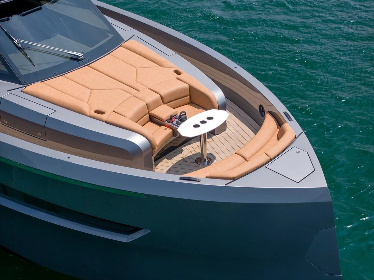 The foredeck features a luxurious sunbathing area with comfortable seating and a small table. aboard GRIT Yacht for Sale