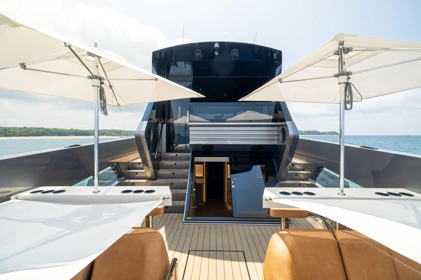 The aft deck features a sleek design with ample seating and sunshade umbrellas, perfect for relaxation. aboard GRIT Yacht for Sale