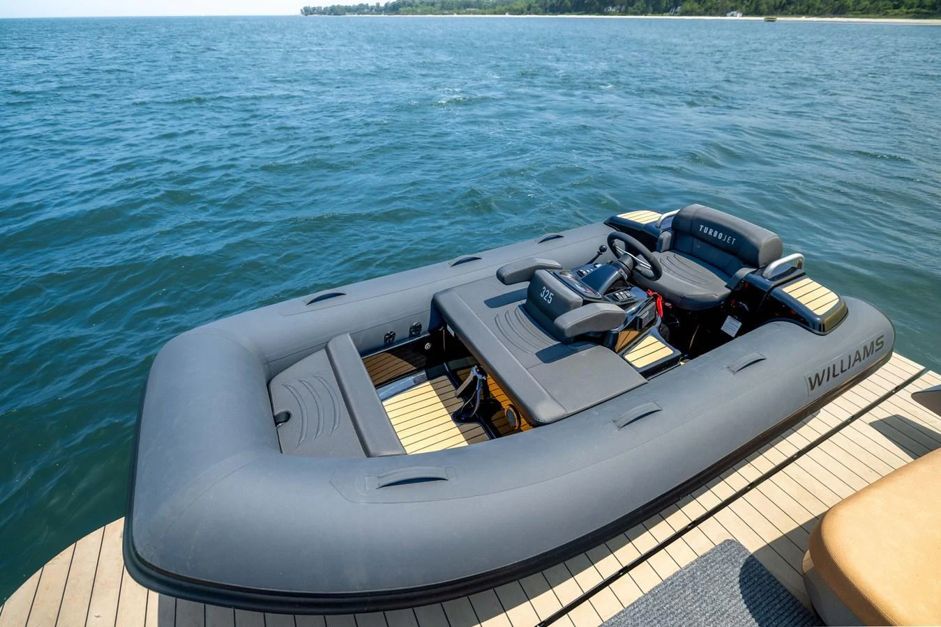 A sleek and modern tender is docked on a calm body of water, ready for use. aboard GRIT Yacht for Sale