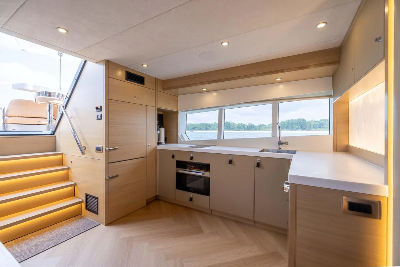 The yacht's galley features modern appliances and ample counter space, illuminated by natural light from large windows. aboard GRIT Yacht for Sale