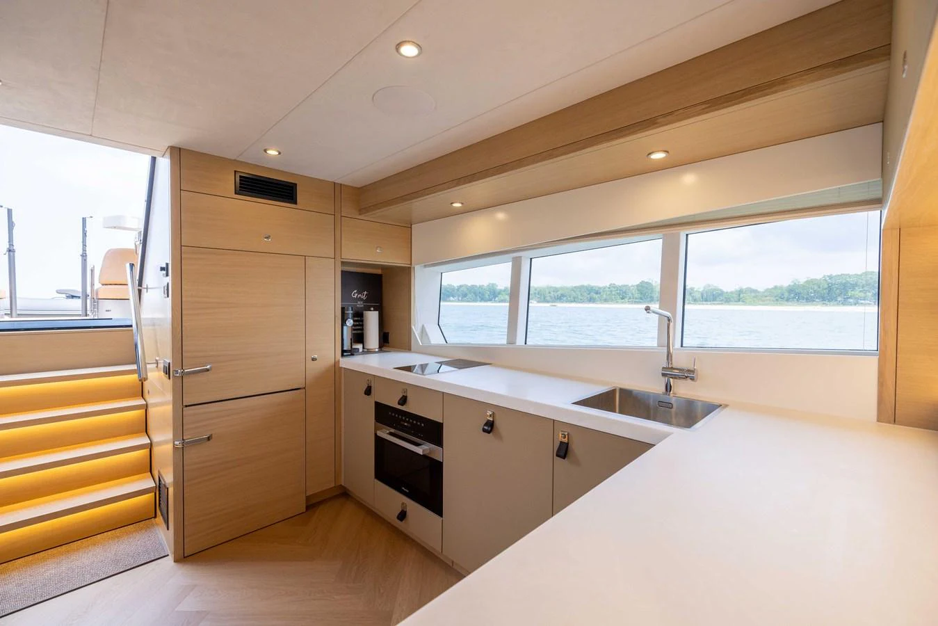 The galley features modern appliances and ample counter space with a view of the water through large windows. aboard GRIT Yacht for Sale