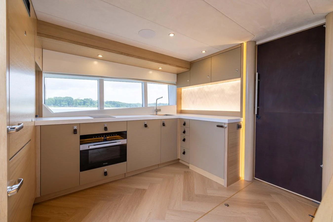 The yacht's galley features modern cabinetry, ample counter space, and large windows for natural light. aboard GRIT Yacht for Sale