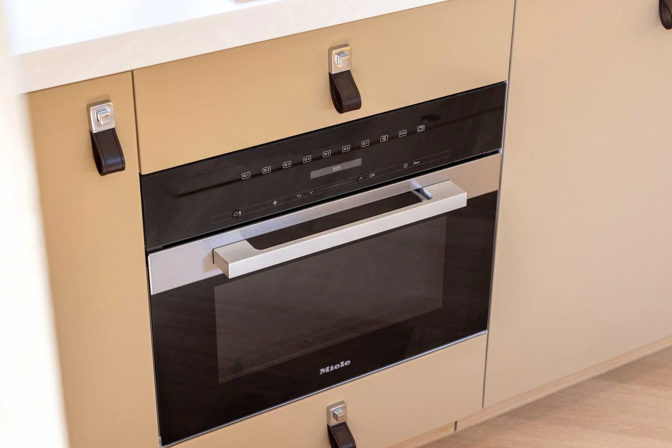 The yacht's galley features a sleek, modern oven integrated into beige cabinetry. aboard GRIT Yacht for Sale