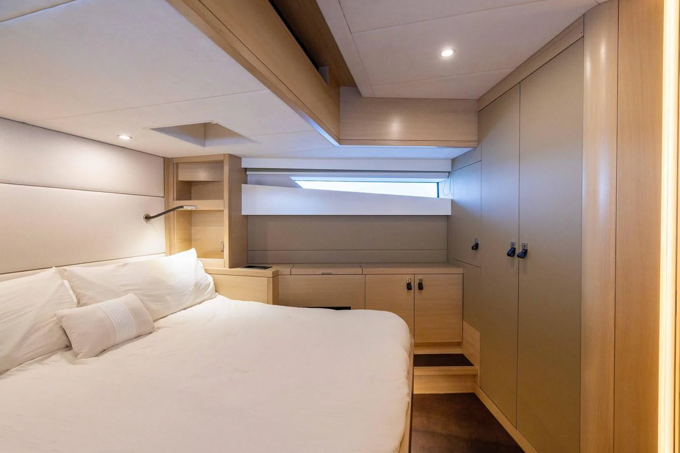 A cozy stateroom featuring a large bed and ample storage space. aboard GRIT Yacht for Sale