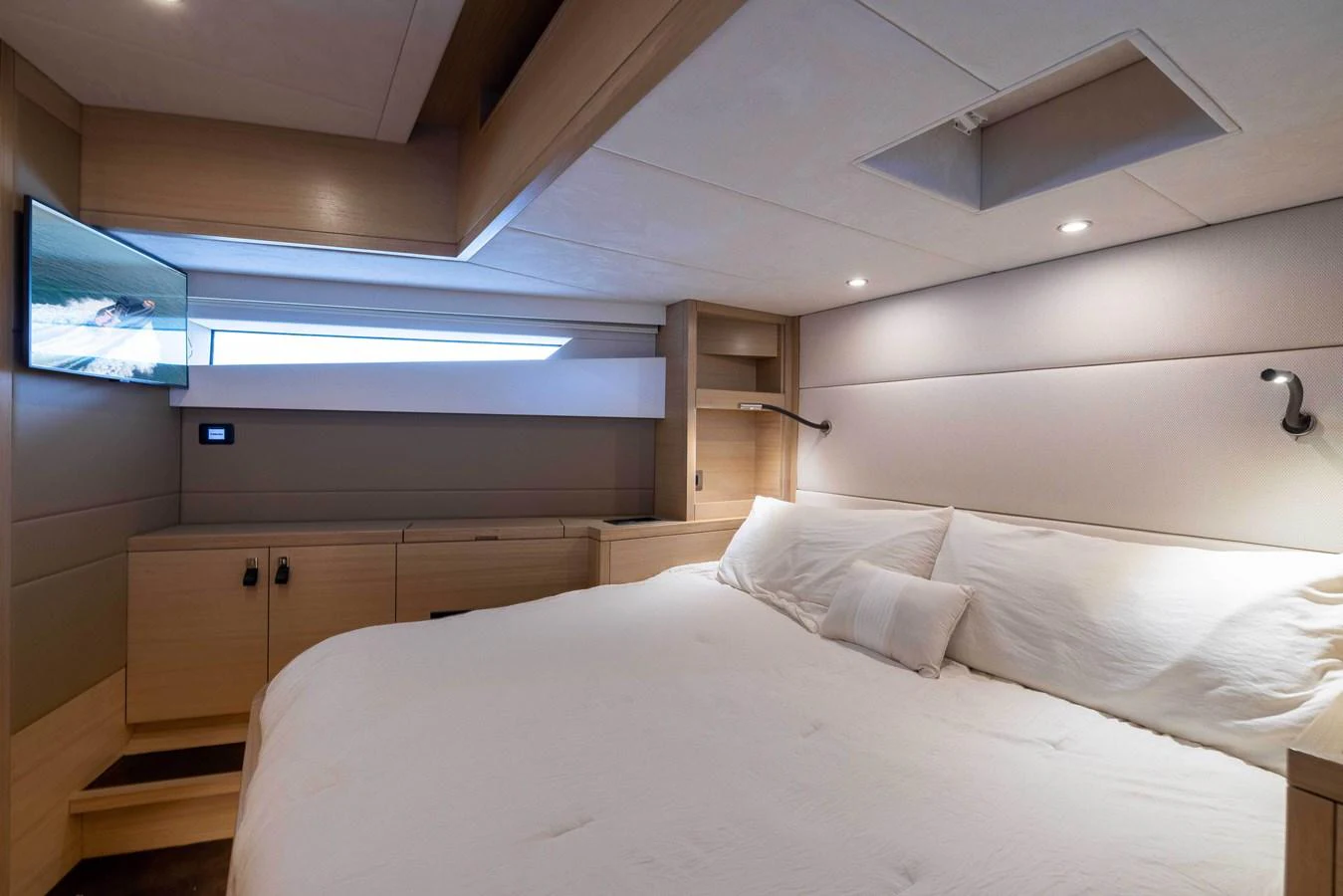 A cozy and modern stateroom featuring a large bed and ambient lighting. aboard GRIT Yacht for Sale
