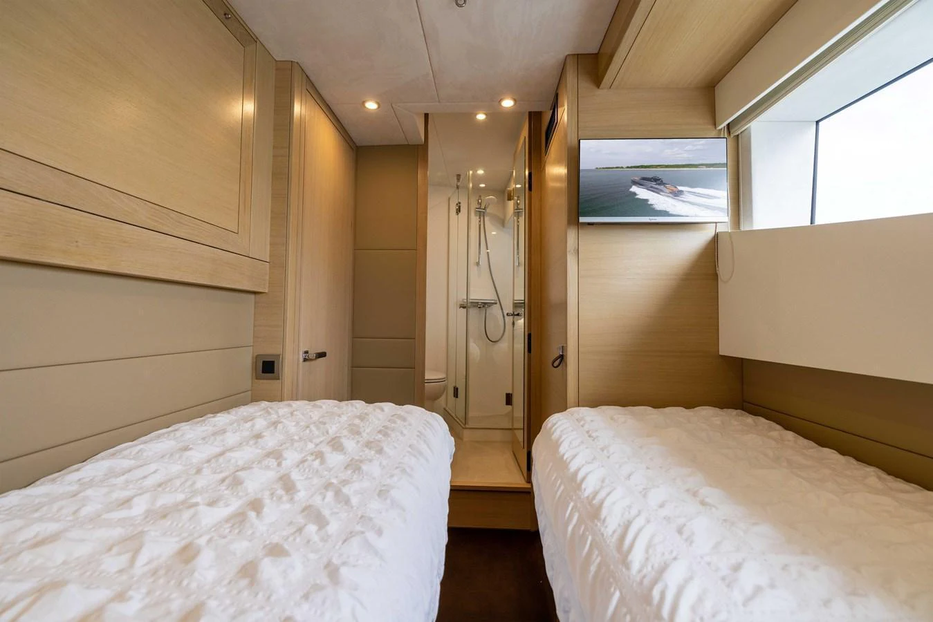 The guest cabin features twin beds, a private ensuite, and a large window for natural light. aboard GRIT Yacht for Sale