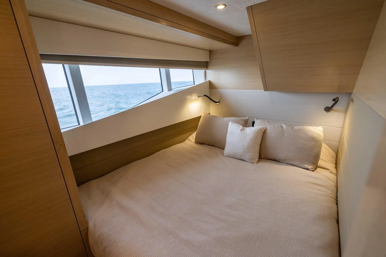 A cozy stateroom with a large bed and ocean view windows. aboard GRIT Yacht for Sale