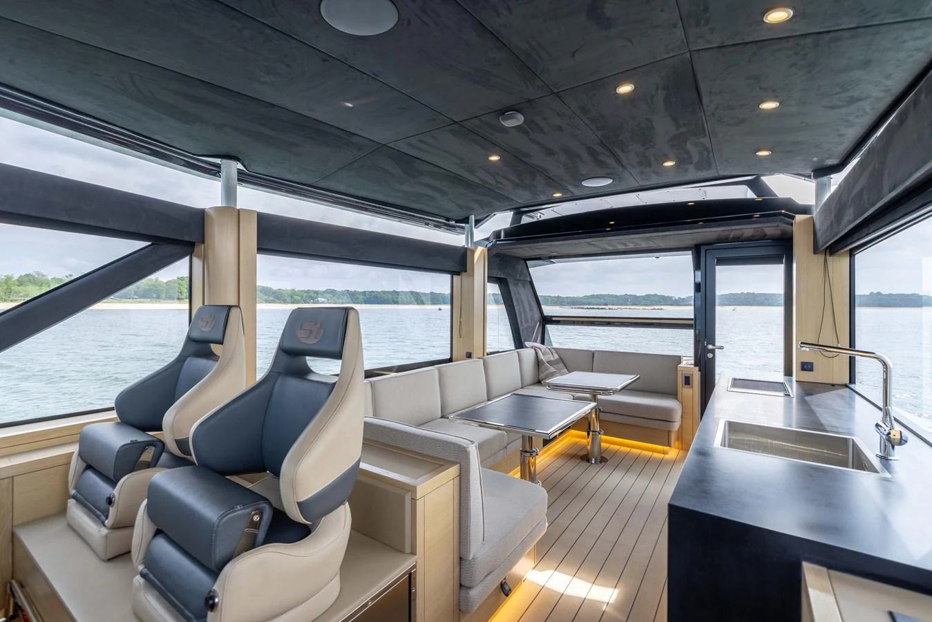 The salon features luxurious seating, a sleek kitchenette, and panoramic windows offering stunning views. aboard GRIT Yacht for Sale