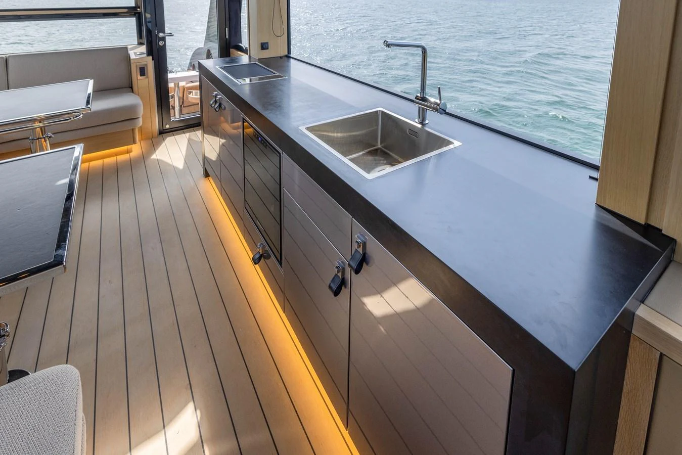 The yacht's galley features sleek countertops and modern fixtures with a view of the water. aboard GRIT Yacht for Sale