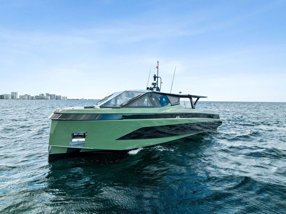 A sleek and modern yacht cruising on open waters with a cityscape in the background. aboard ANOTHER WORLD Yacht for Sale