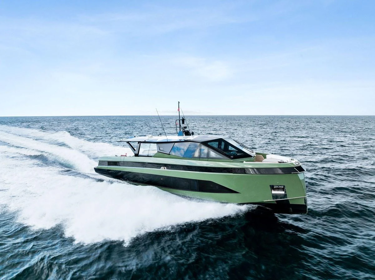 A sleek, modern yacht cruises swiftly across open waters under a clear blue sky. aboard ANOTHER WORLD Yacht for Sale