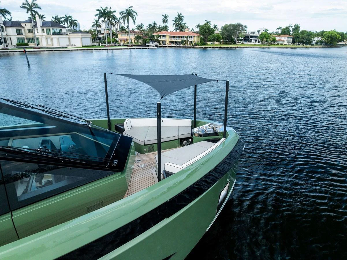 The yacht features a sleek exterior design with a shaded seating area at the bow, perfect for relaxing on the water. aboard ANOTHER WORLD Yacht for Sale