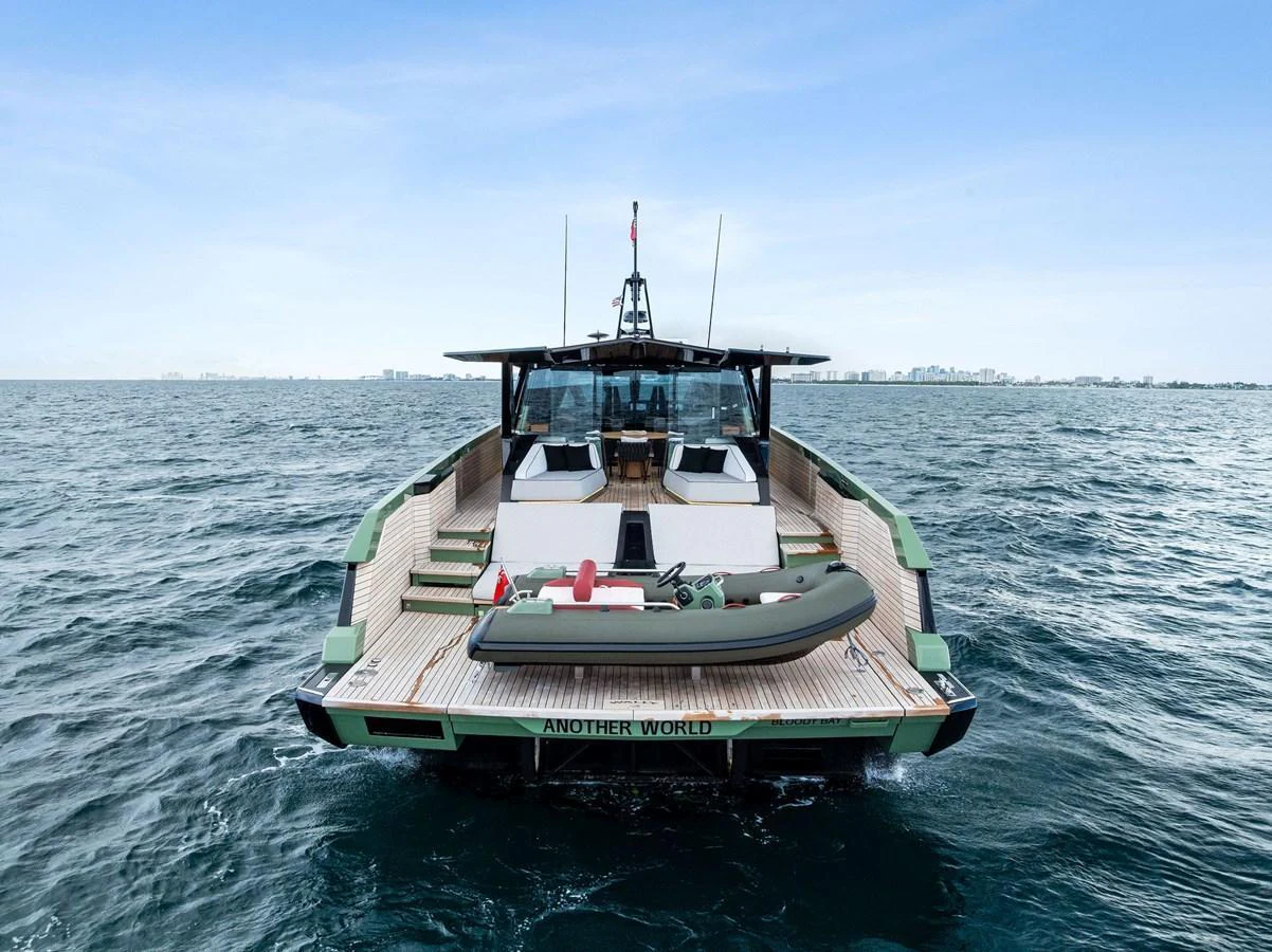 The yacht's aft deck features a spacious lounging area with a tender secured at the stern. aboard ANOTHER WORLD Yacht for Sale