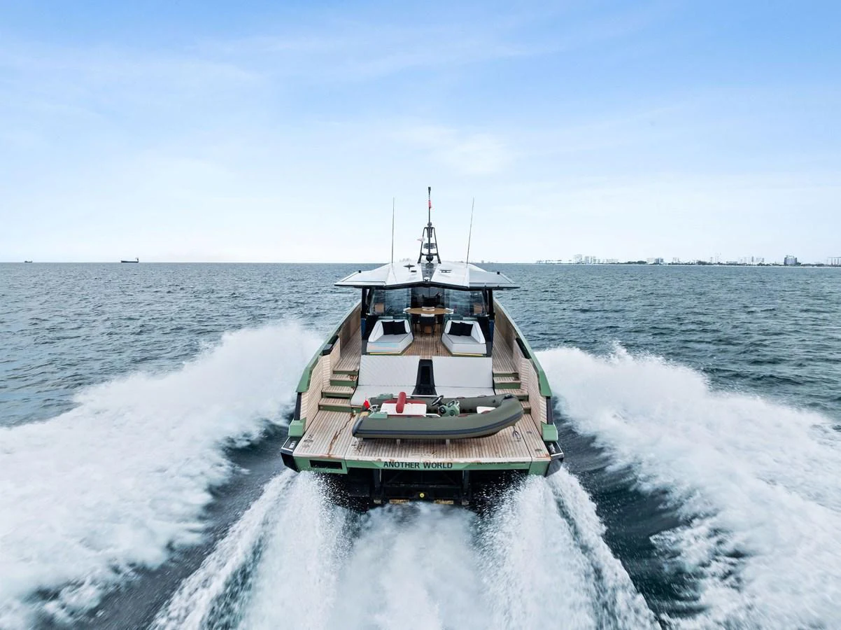 A sleek yacht cruises swiftly through the open water, leaving a trail of white wake behind. aboard ANOTHER WORLD Yacht for Sale