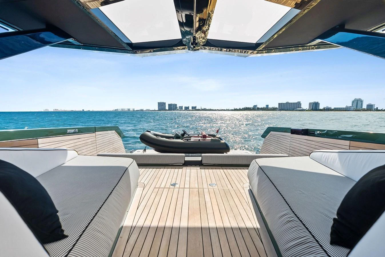 The aft deck offers a luxurious lounging area with a stunning view of the sea and skyline. aboard ANOTHER WORLD Yacht for Sale