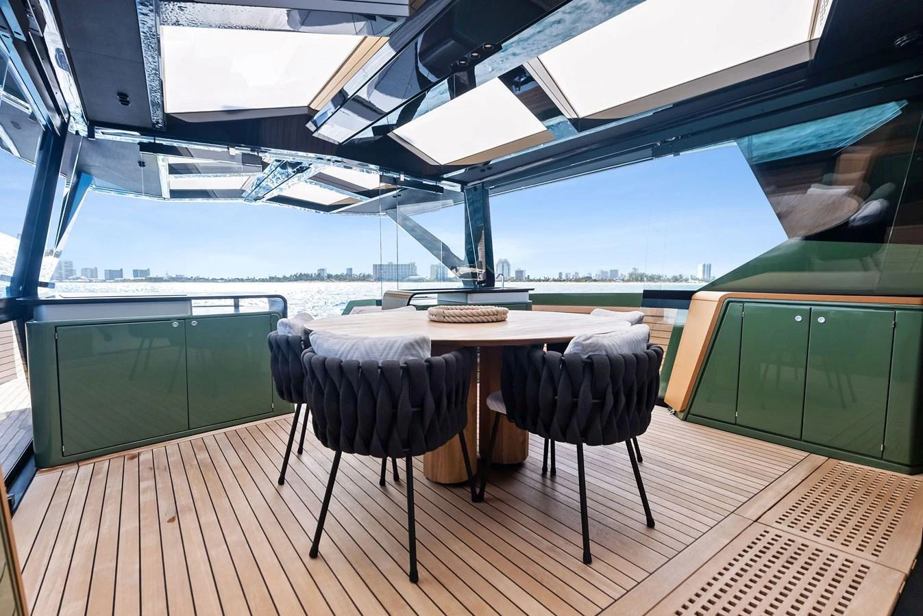 The aft deck features a stylish dining area with a round table and comfortable seating, perfect for alfresco meals. aboard ANOTHER WORLD Yacht for Sale