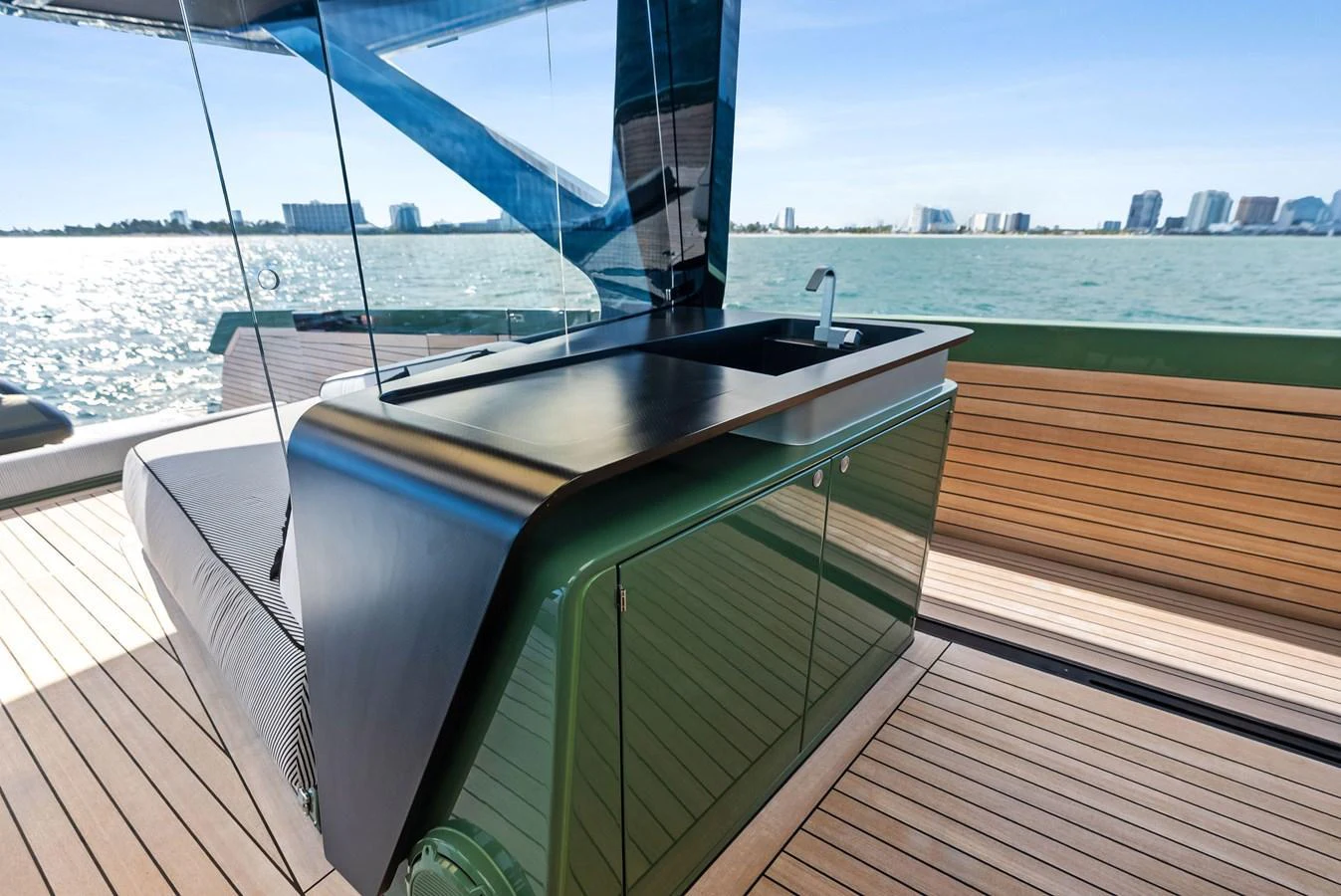 The yacht features a sleek outdoor galley with modern amenities and a stunning waterfront view. aboard ANOTHER WORLD Yacht for Sale