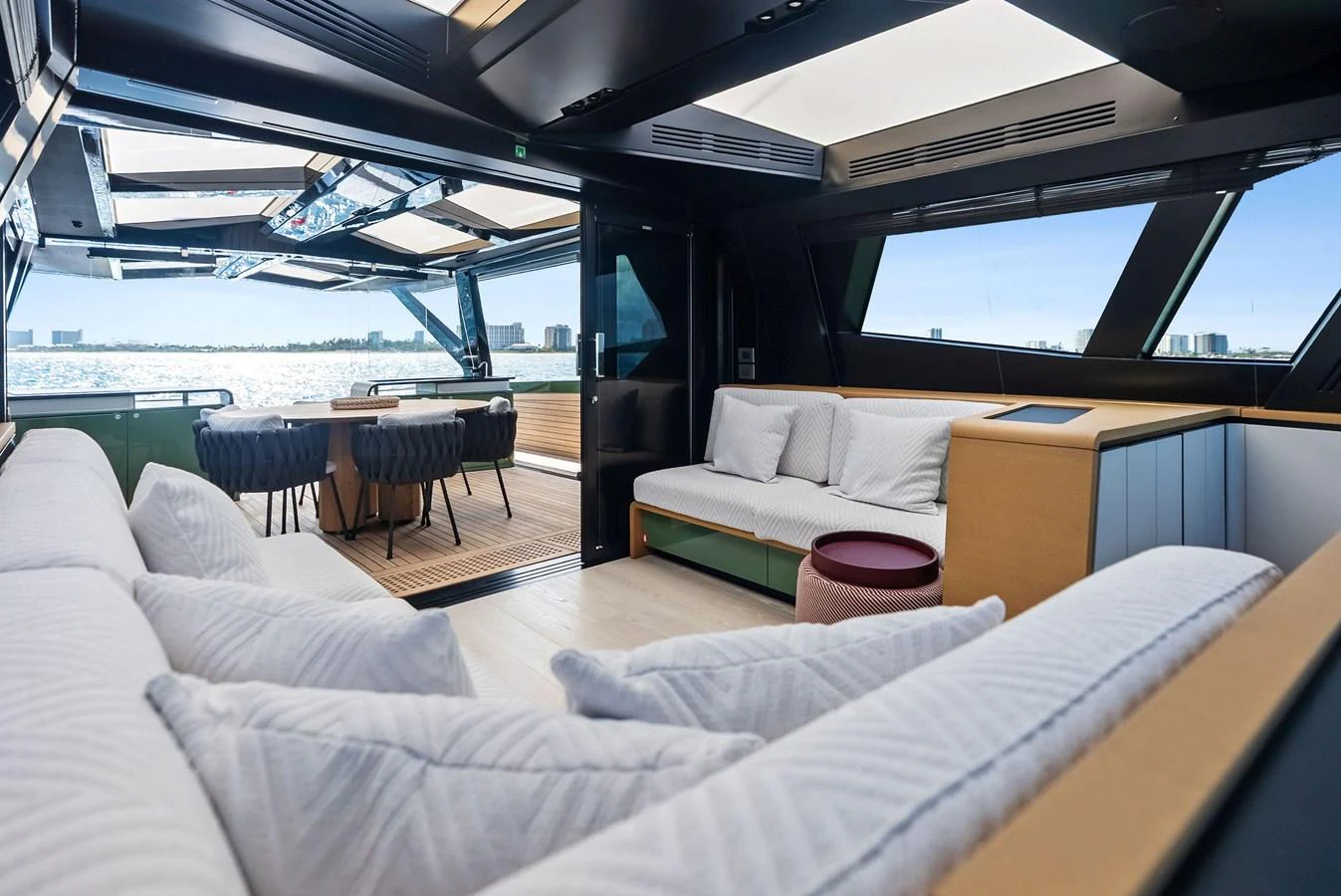 The salon offers a spacious and modern seating area with a view of the open deck and the sea beyond. aboard ANOTHER WORLD Yacht for Sale
