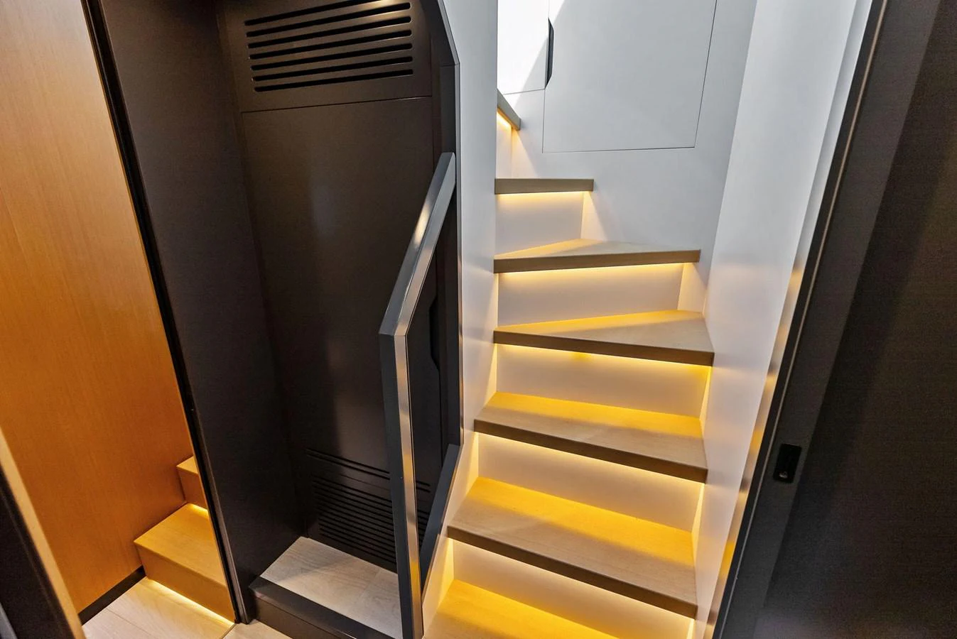 A modern, well-lit staircase with sleek design elements inside the yacht. aboard ANOTHER WORLD Yacht for Sale