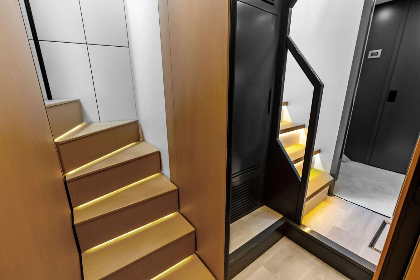 A modern staircase with sleek lighting leads to different levels of the yacht's interior. aboard ANOTHER WORLD Yacht for Sale