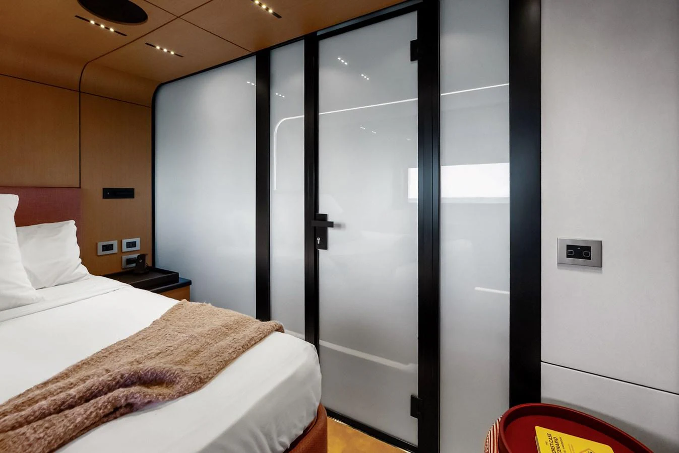 The stateroom features a modern design with frosted glass doors and warm wood accents. aboard ANOTHER WORLD Yacht for Sale
