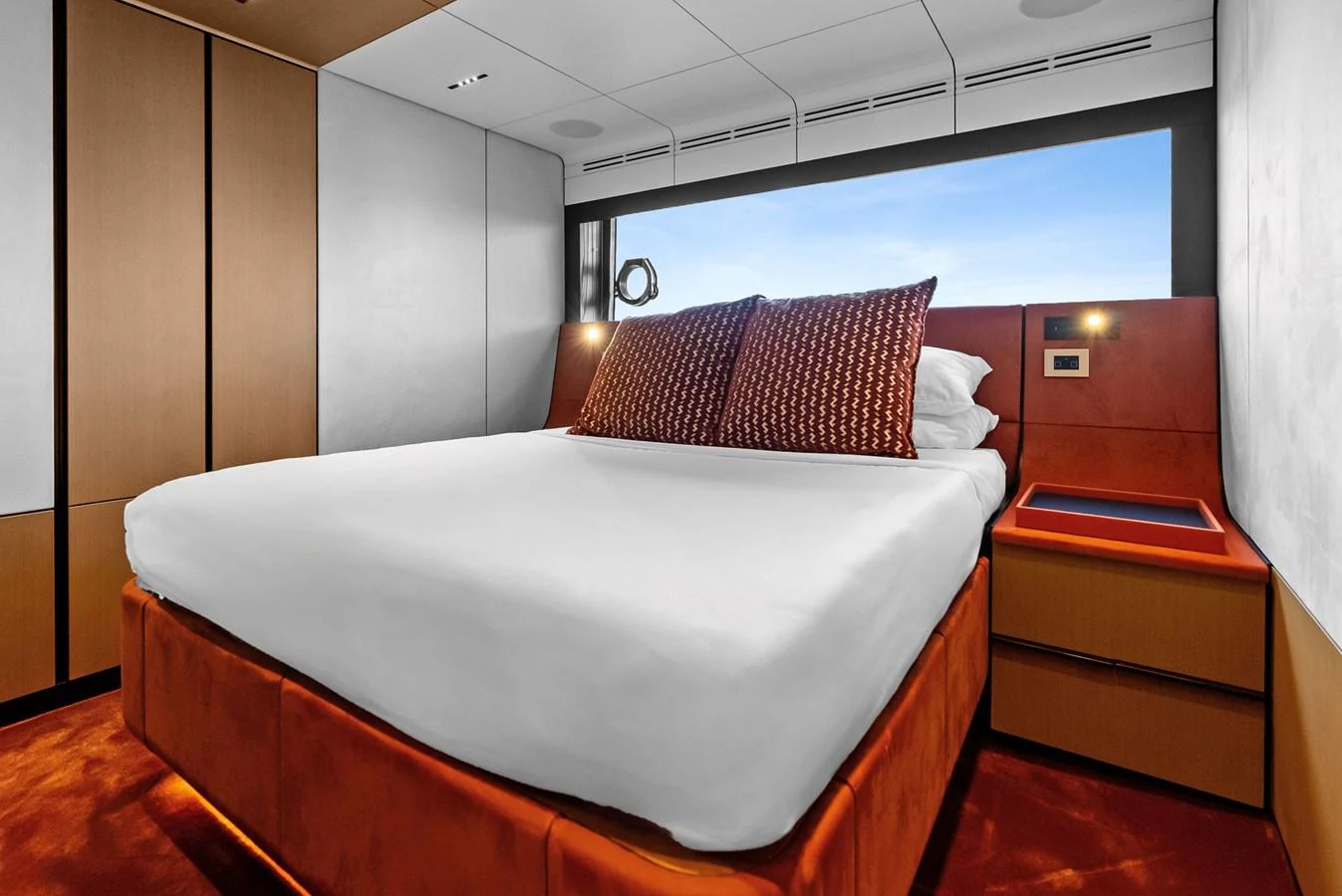 A cozy stateroom featuring a large bed with plush pillows and modern furnishings. aboard ANOTHER WORLD Yacht for Sale