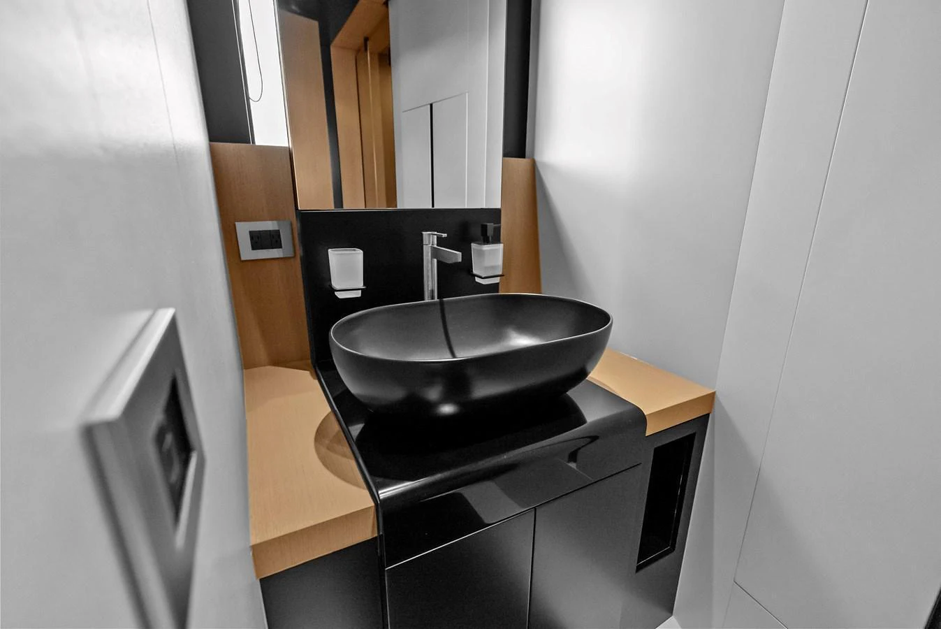 A sleek and modern bathroom with a black vessel sink and minimalist design. aboard ANOTHER WORLD Yacht for Sale