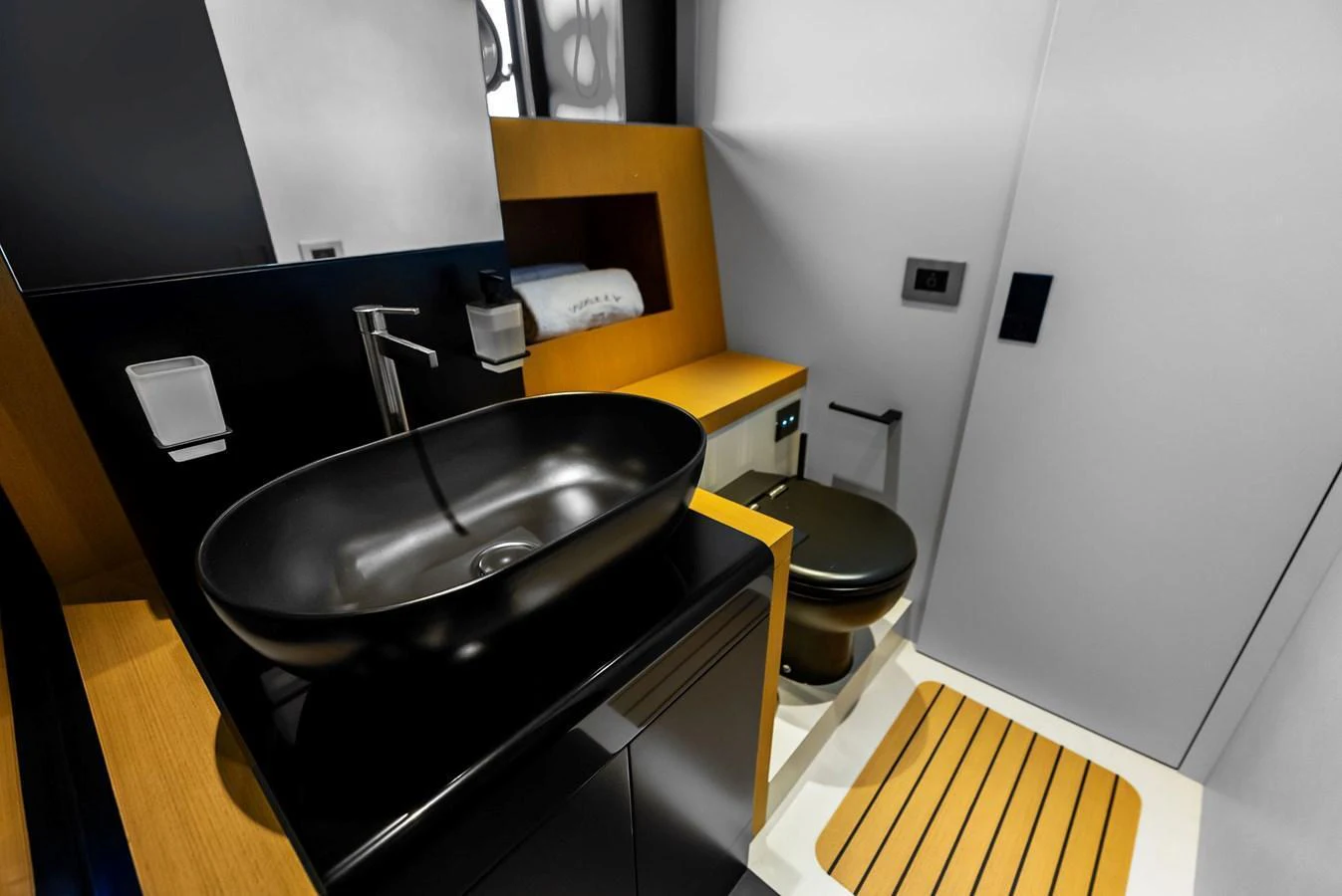 A modern yacht bathroom featuring sleek black fixtures and wooden accents. aboard ANOTHER WORLD Yacht for Sale