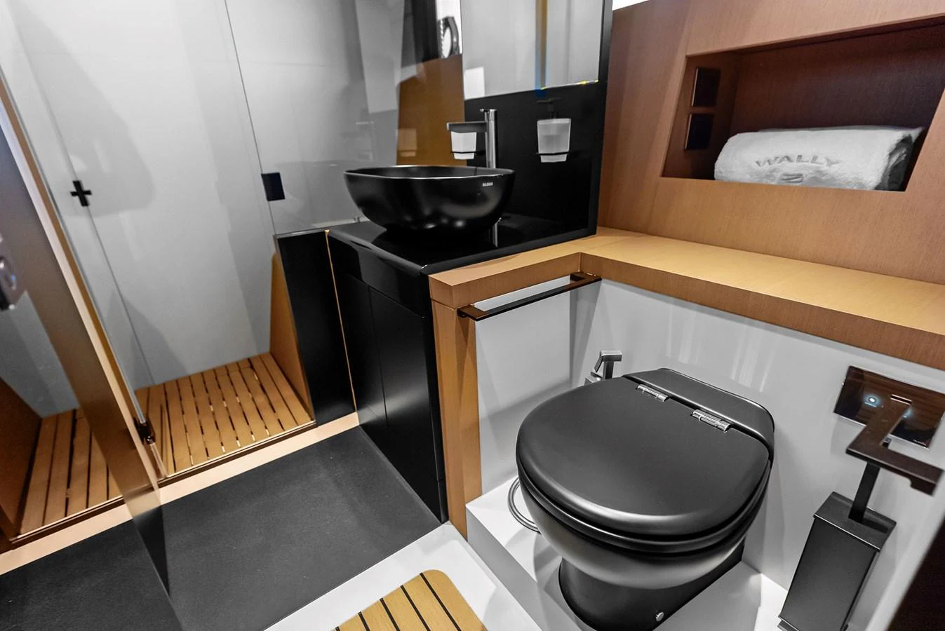 A sleek and modern yacht bathroom with black fixtures and wooden accents. aboard ANOTHER WORLD Yacht for Sale