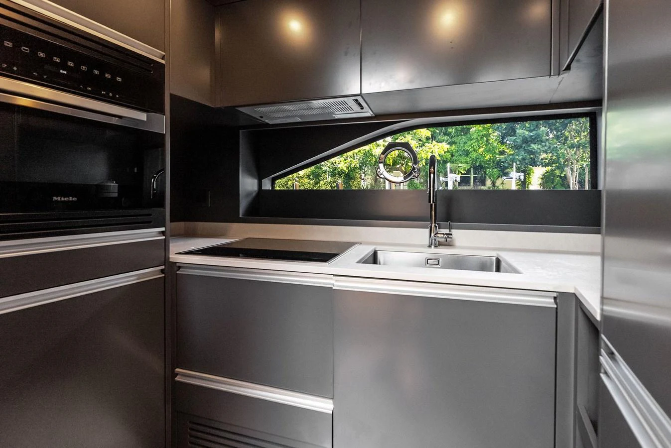 A sleek and modern galley with high-end appliances and a scenic window view. aboard ANOTHER WORLD Yacht for Sale
