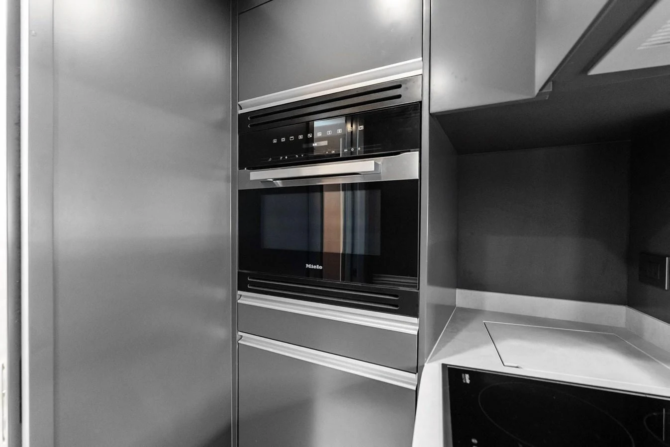 The modern galley features sleek built-in appliances and a minimalist design. aboard ANOTHER WORLD Yacht for Sale