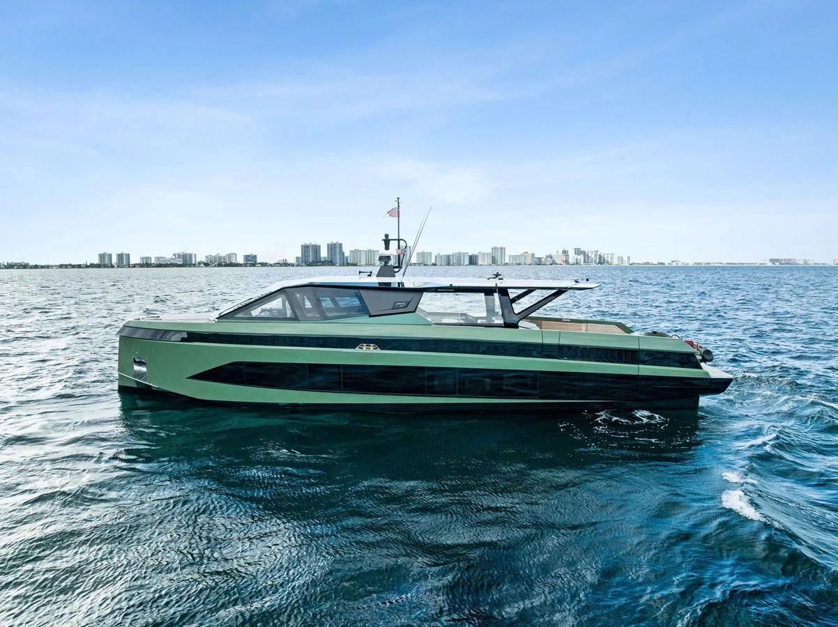 A sleek, modern yacht cruises on calm waters with a city skyline in the background. aboard ANOTHER WORLD Yacht for Sale
