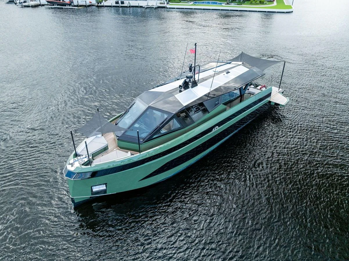 A sleek, modern yacht with a distinctive green hull cruising on calm waters. aboard ANOTHER WORLD Yacht for Sale