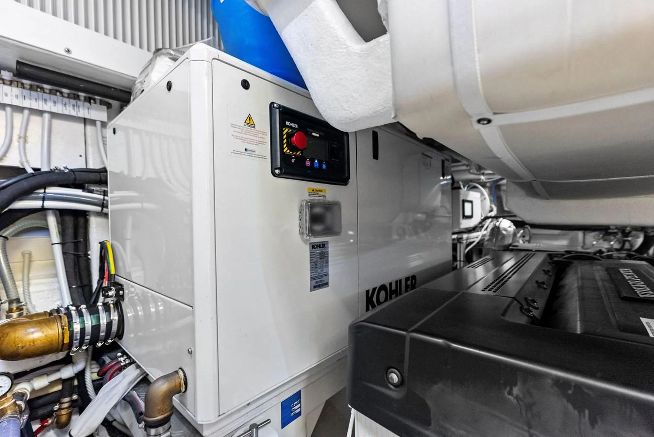The image showcases the engine room featuring a Kohler generator and various mechanical components. aboard ANOTHER WORLD Yacht for Sale