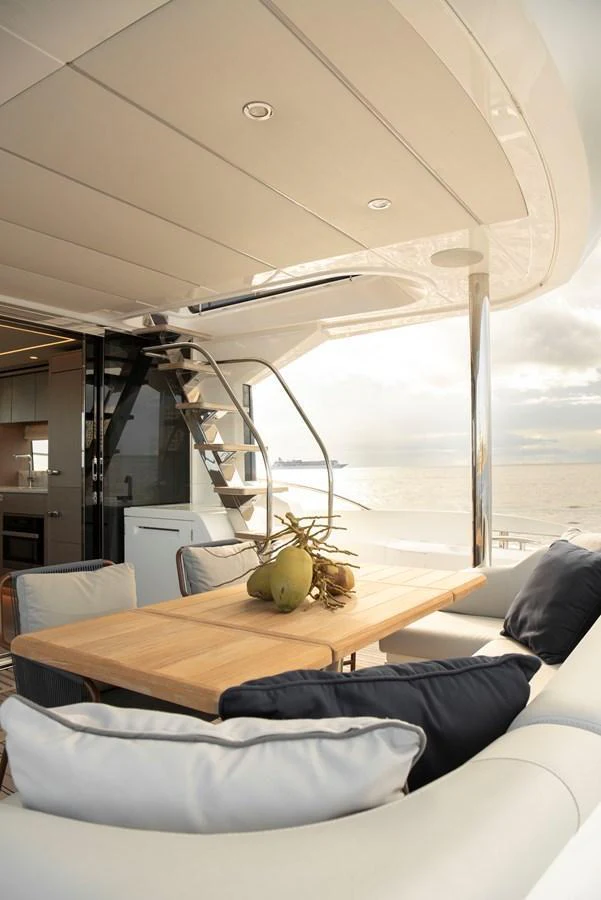 The aft deck features a stylish dining area with a wooden table and comfortable seating, perfect for enjoying meals with a view of the sea. aboard GAIA Yacht for Sale