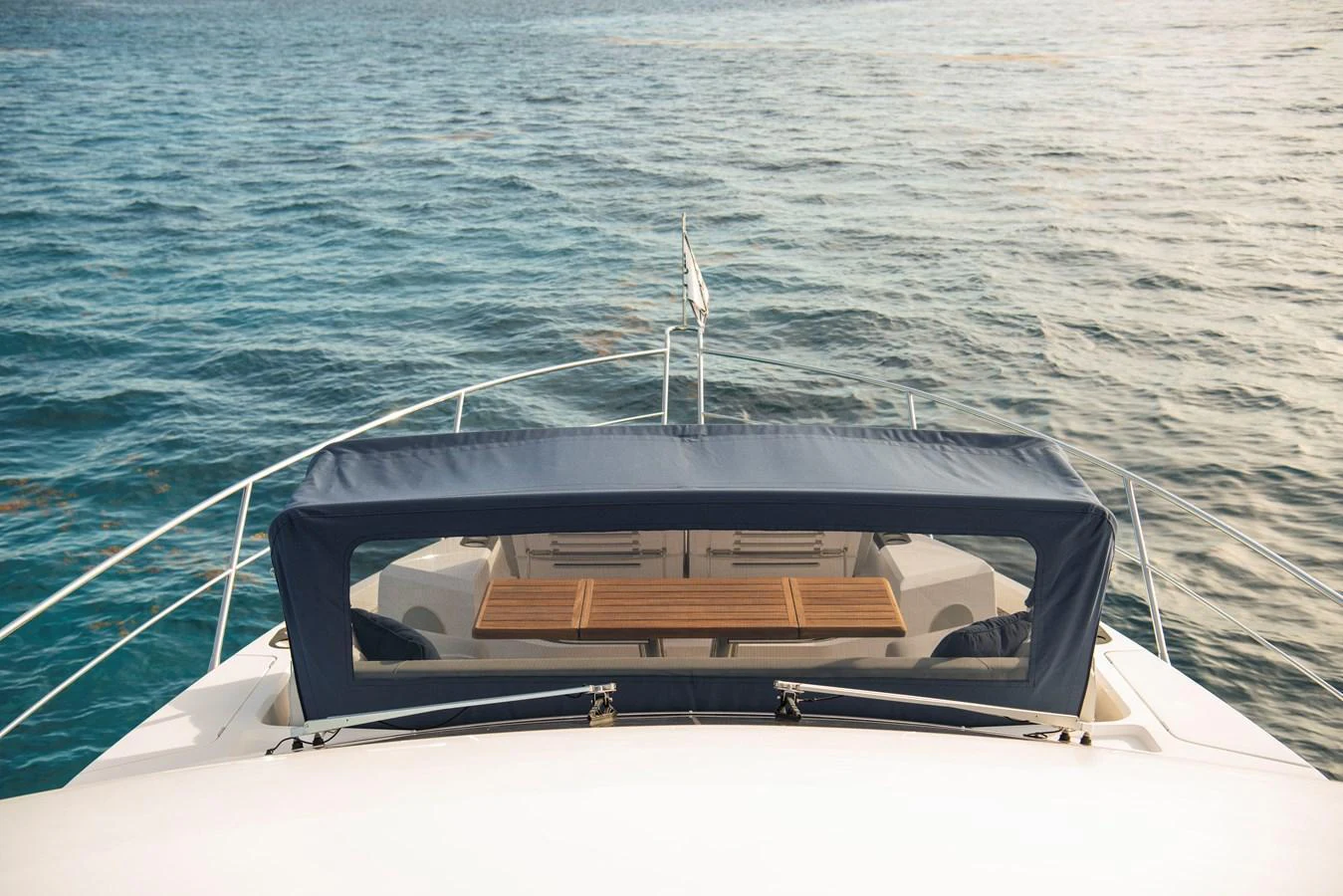 The yacht's bow features a comfortable seating area with a wooden table, perfect for enjoying the ocean view. aboard GAIA Yacht for Sale