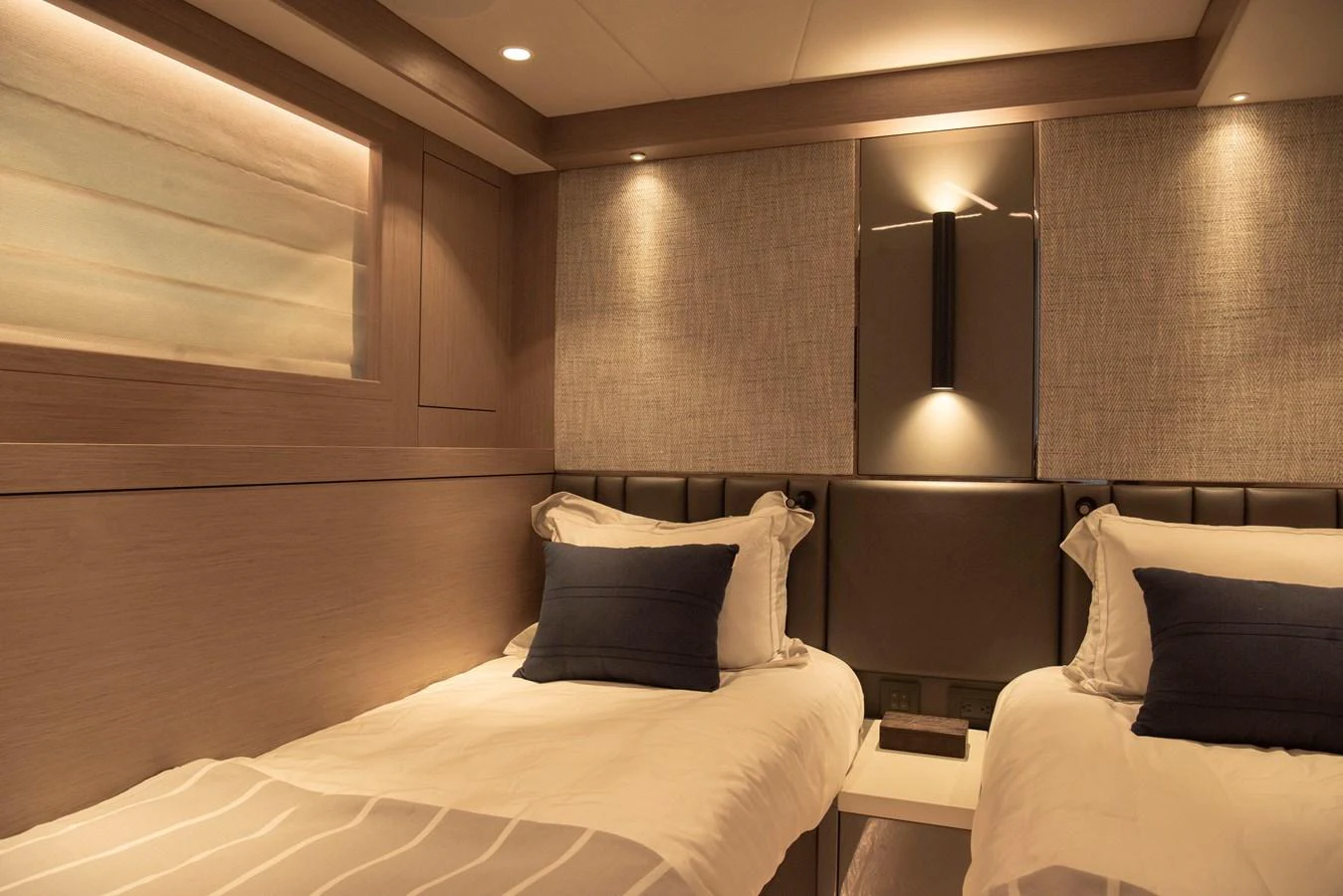 The guest stateroom features twin beds with elegant lighting and modern decor. aboard GAIA Yacht for Sale
