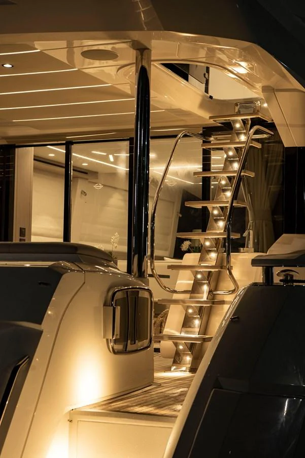 A close-up view of a yacht's illuminated staircase leading to the upper deck, showcasing modern design and ambient lighting. aboard GAIA Yacht for Sale