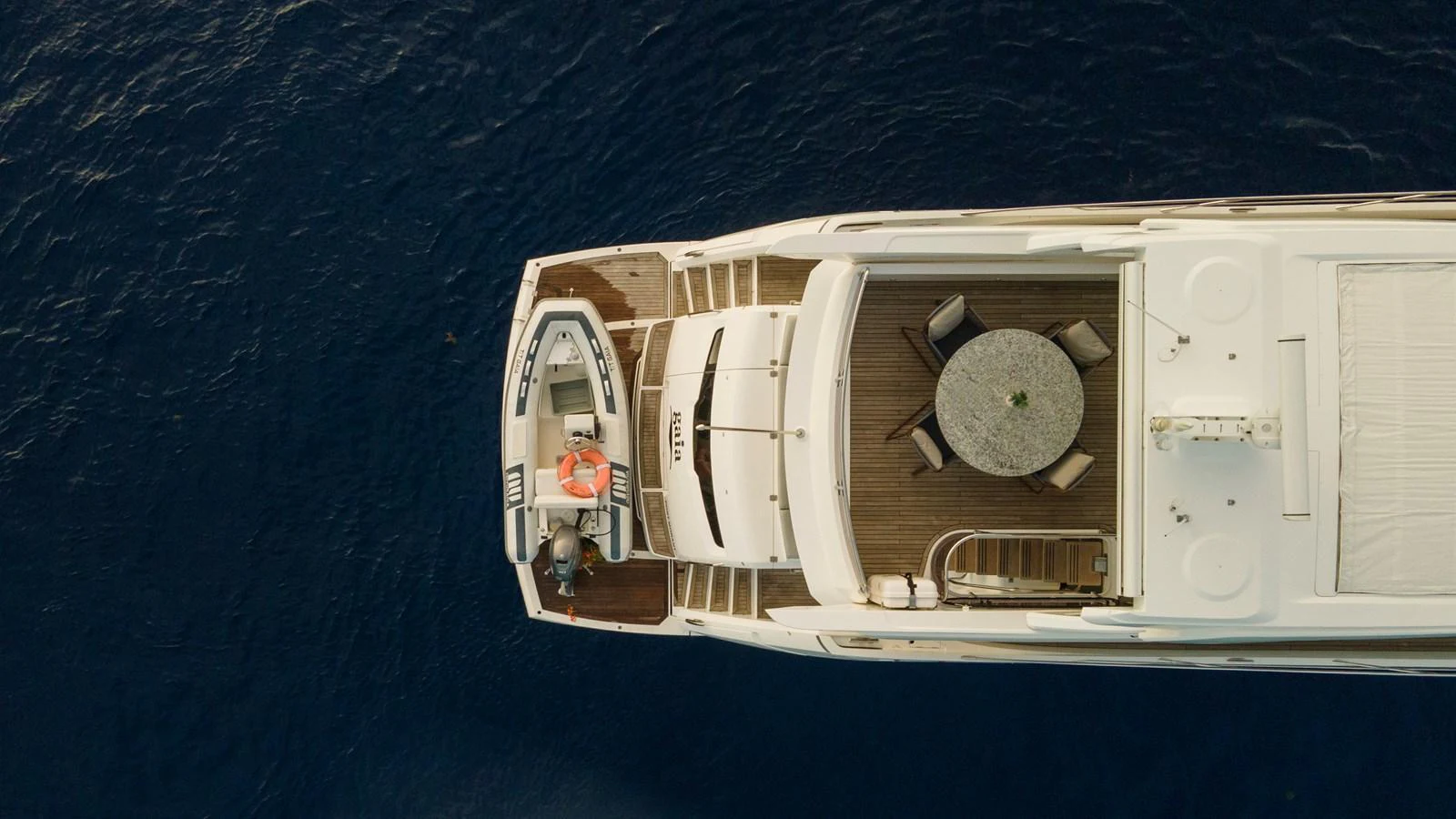Aerial view of the yacht's aft deck featuring a dining area and tender. aboard GAIA Yacht for Sale