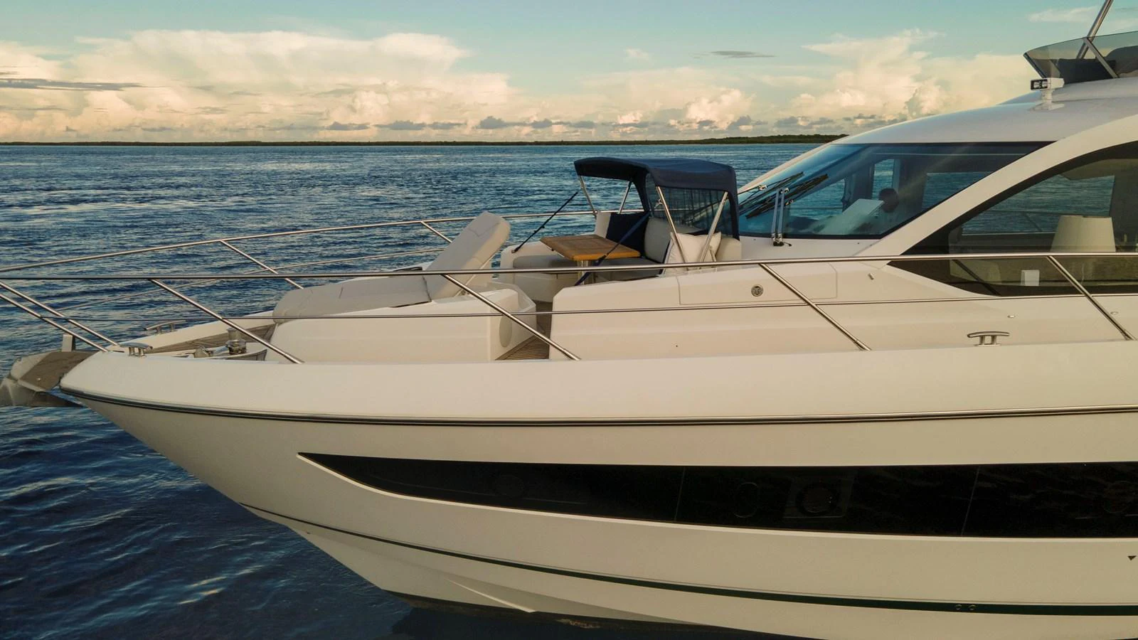 A sleek and modern yacht cruising on calm waters under a clear sky. aboard GAIA Yacht for Sale