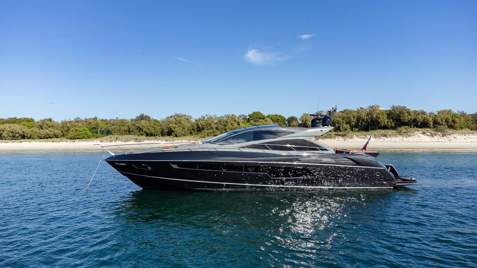 A sleek, modern yacht cruises along the coastline under a clear blue sky. aboard ZAZA Yacht for Sale