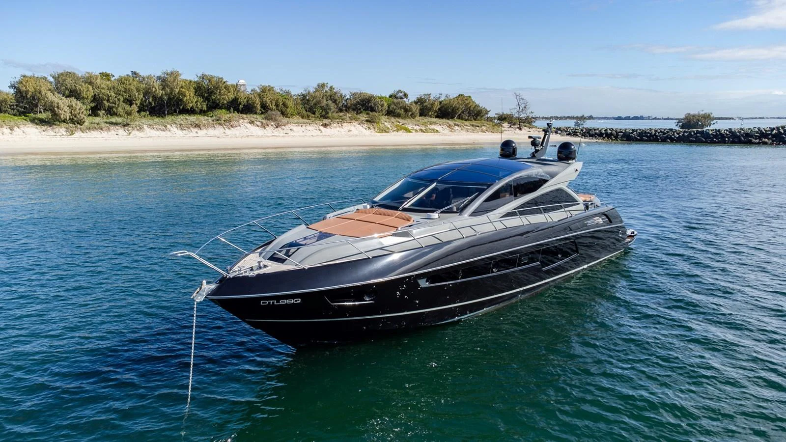 A sleek and modern yacht glides gracefully on calm waters near a scenic shoreline. aboard ZAZA Yacht for Sale
